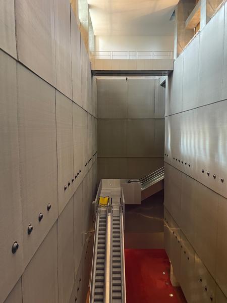 A view from the top of one of the towers down into the courtyard. You can see the base of one tower, and the walkways that lead to the entrance. You can also see some of the trees in the wooded area, which is below ground level.